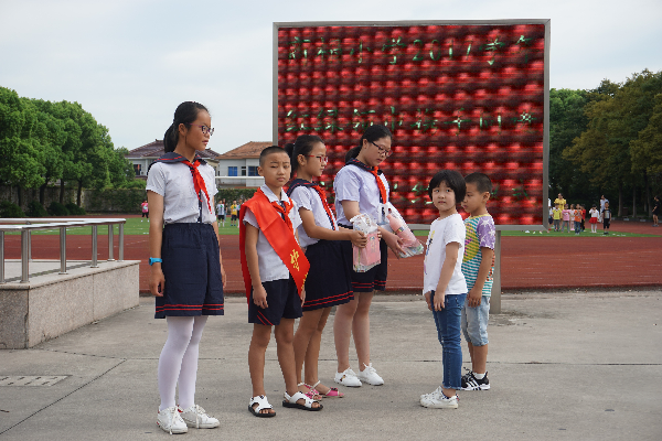 开学仪式上,大队部进行了四五年级和一二年级的"红绿领巾携手同进